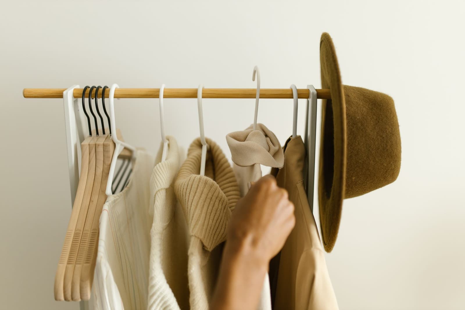 Beige and brown clothes on a rail.